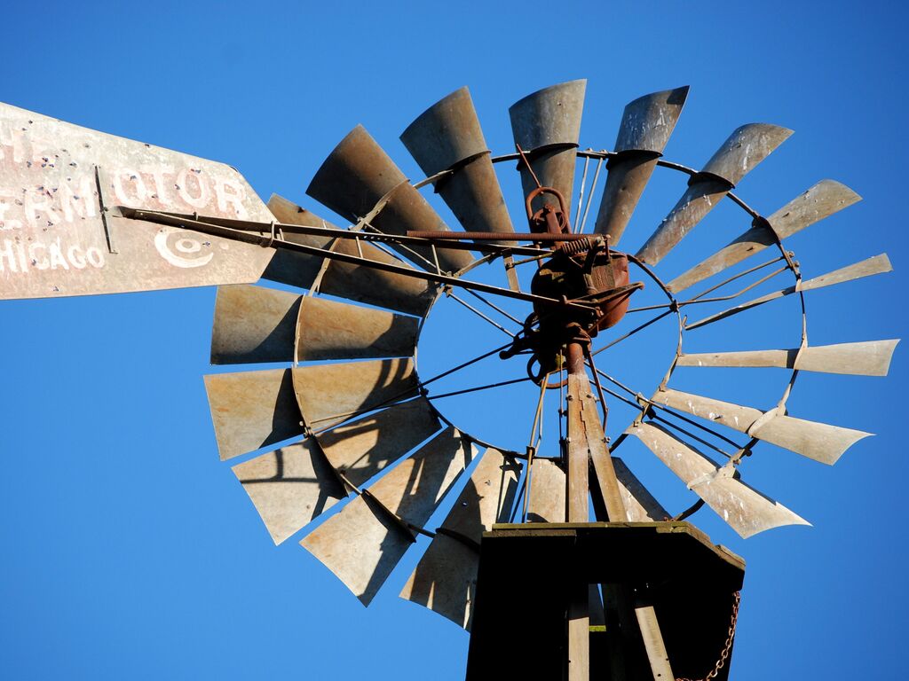 Vintage farm windmill against a blue sky near Appellation Petaluma in Sonoma County wine country